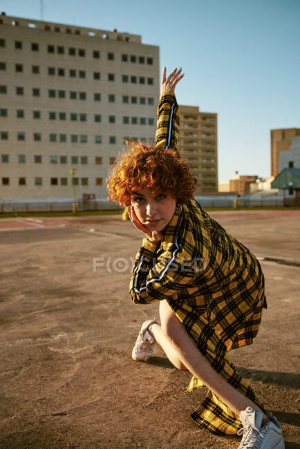 Ruiva encaracolado jovem dançando em um estacionamento vazio — Fotografia de Stock