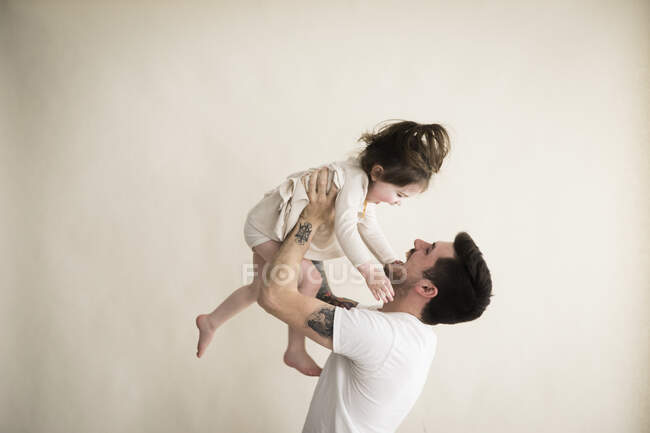 Happy Millennial Hipster Father Holds Toddler Girl Above His Head — Stock Photo