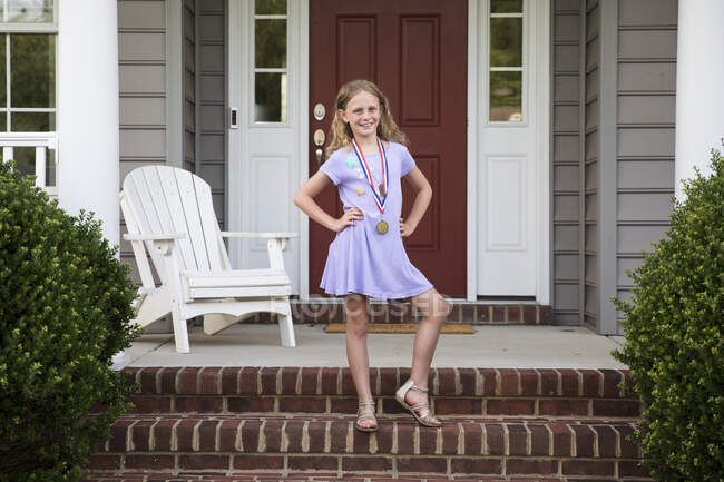 Sorridente sassy bionda ragazza indossare medaglia oses su mattone anteriore passi — Foto stock