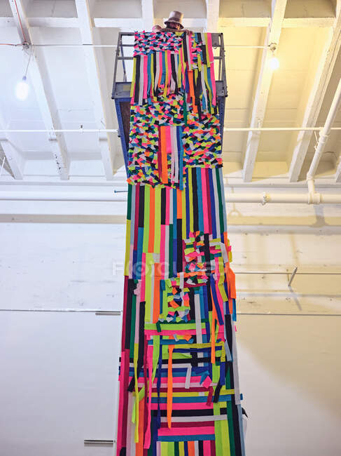 Künstler installiert großen bunten Wandteppich von einer Scherenbühne. — Stockfoto
