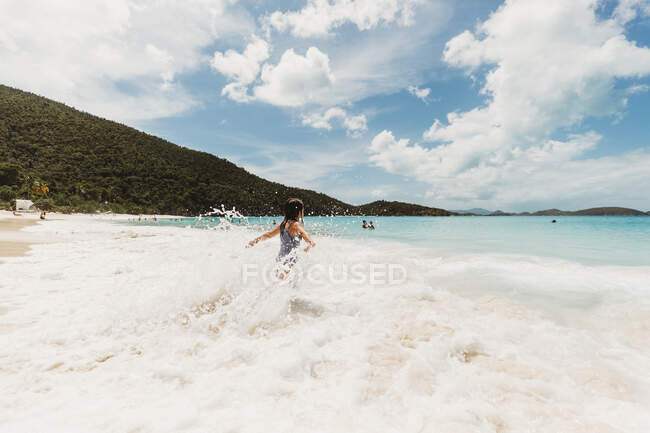 Ragazza gioca nelle onde tropicali nelle isole dei Caraibi — Foto stock