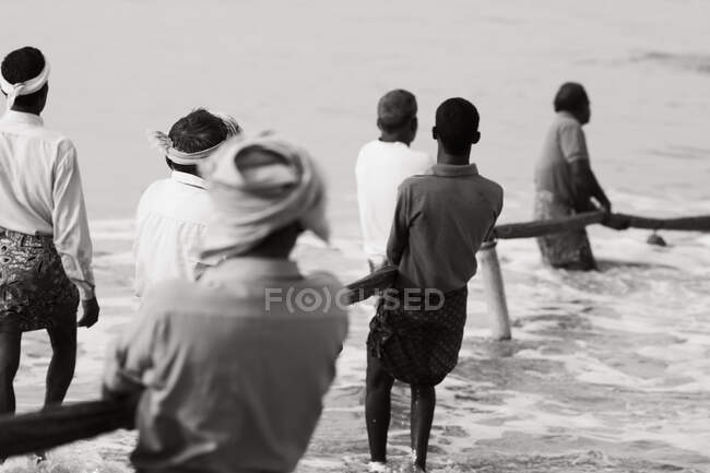 Indian fishermen pulling up net from the sea — Stock Photo