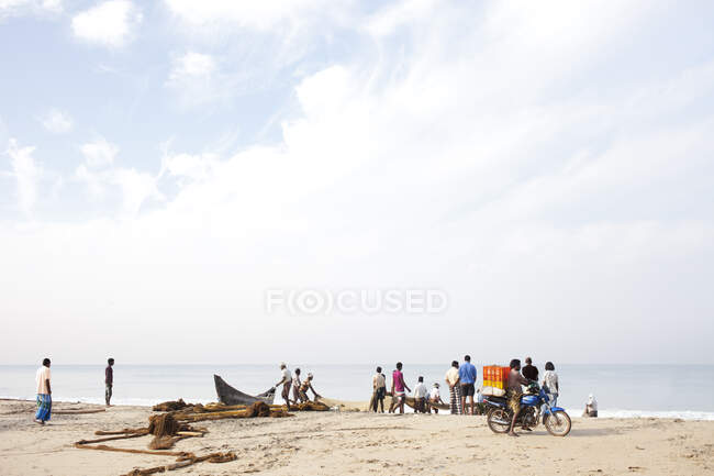 Pescadores indios recogen las capturas de hoy en la playa - foto de stock