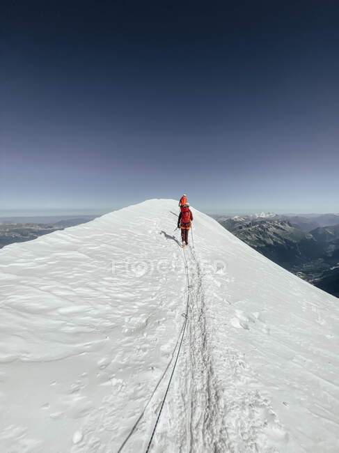 Pessoas andando montanha abaixo com neve nas montanhas — Fotografia de Stock