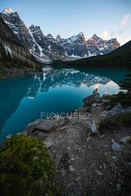 Hermoso paisaje de lago de montaña, chica sentada en la roca - foto de stock