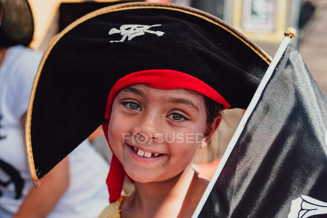 Крупный план портрет 8-летней многорасовой девушки в черной пиратской шляпе — стоковое фото