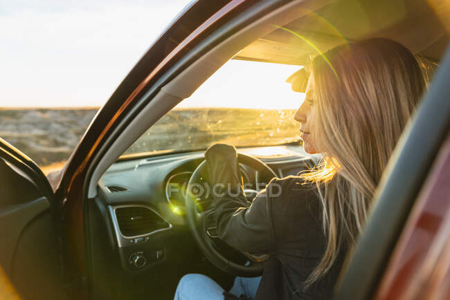 Frau fährt von Straße ab, um Land bei Sonnenuntergang zu erwischen — Stockfoto