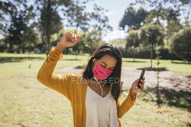 Молода жінка з навушниками слухає музику на смартфоні — стокове фото