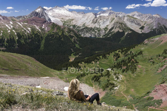Caminhante feminina olhando para a vista enquanto relaxa na montanha — Fotografia de Stock