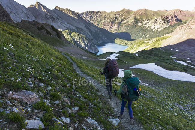 Caminhantes femininos com mochilas na montanha — Fotografia de Stock