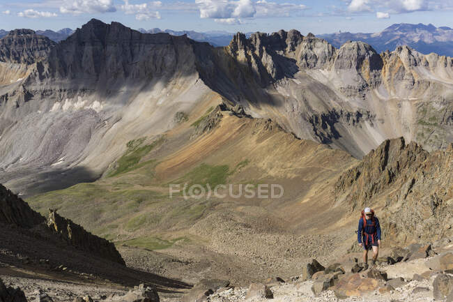 Joven senderismo en la montaña durante el verano - foto de stock