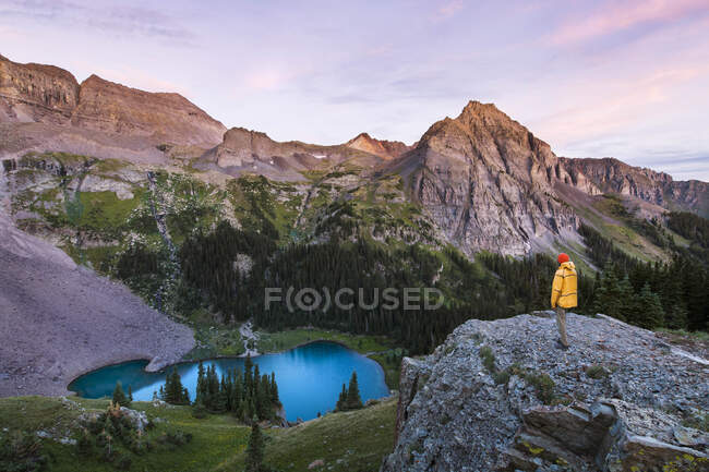 Männlicher Wanderer steht bei Sonnenuntergang auf dem Berg — Stockfoto