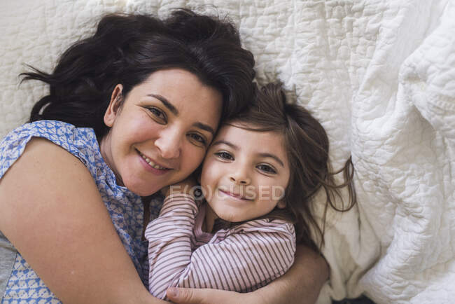 Snuggle time for happy mid-30's mom and 6 yr old daughter — Stock Photo