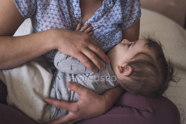 Bebê contente olhando para a mãe enquanto amamenta — Fotografia de Stock