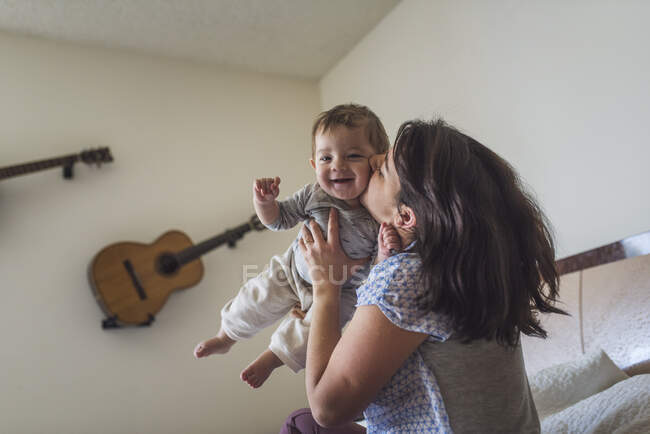 Mother and baby lying on bed in the bedroom — Stock Photo