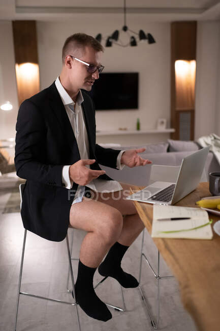 Повне тіло наполовину одягнений чоловік менеджер має онлайн-зустріч під час роботи вдома — стокове фото