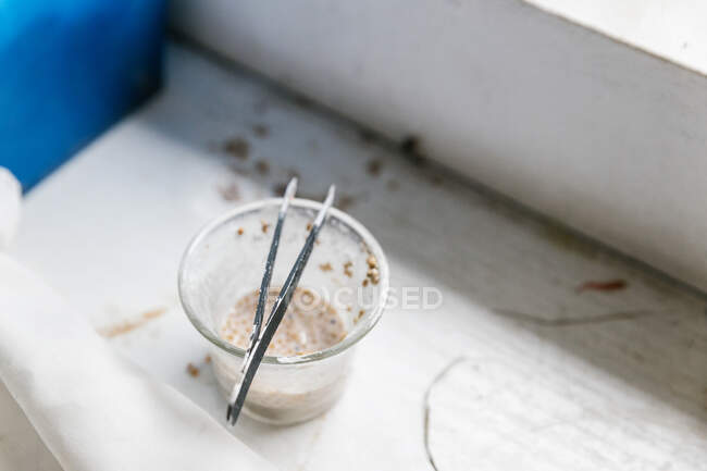 Du dessus tasse de liquide nutritif avec des graines pour l'alimentation des oiseaux placés — Photo de stock