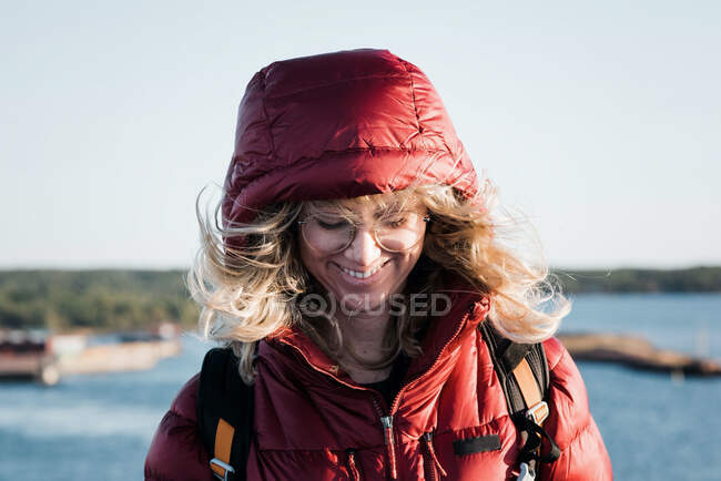 Femme debout avec ses cheveux soufflant dans le vent tandis que la randonnée en plein air — Photo de stock