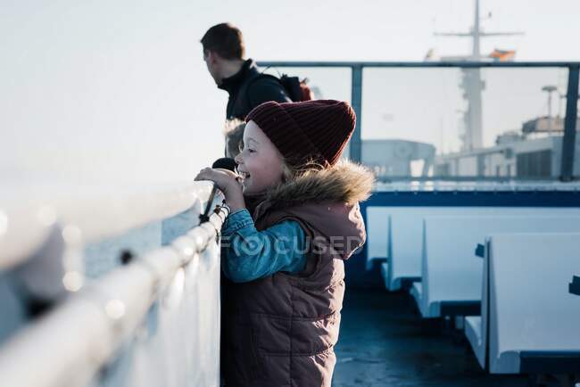 Jeune fille regardant excité tout en voyageant sur un ferry — Photo de stock