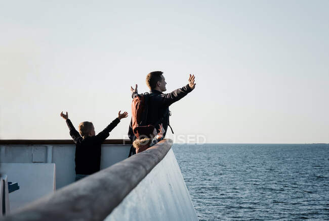 Отец и его дети играют в титаника, чувствуя бриз на лодке. — стоковое фото