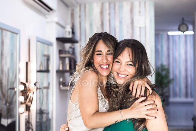 Dos mujeres cariñosas felices abrazándose en un abrazo cercano - foto de stock