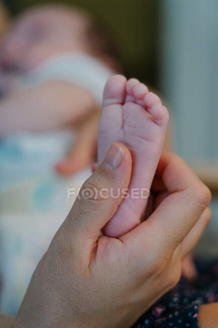 Madre accarezzando il piede del suo bambino — Foto stock