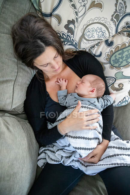Neugeborenes Baby schläft bei seiner liebevollen Mutter. — Stockfoto