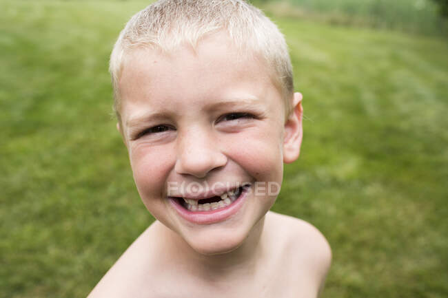 Close Up of Smiling Toothless Young Boy With a Buzz Cut in Backyard — Stock Photo