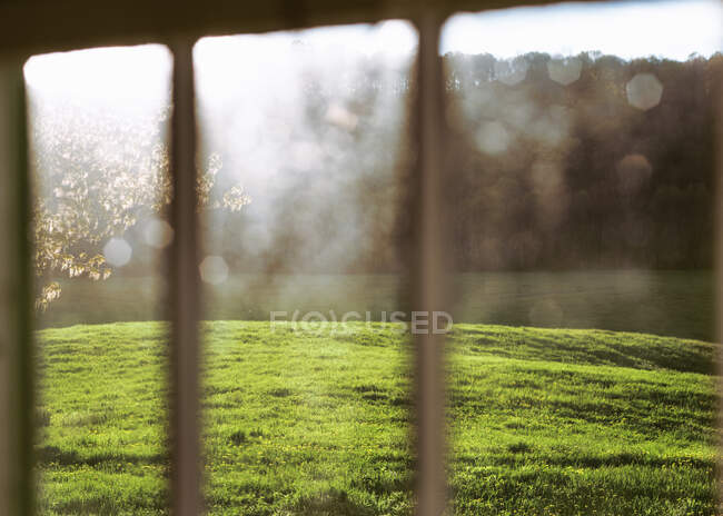 Caída de la luz del sol en un campo a través de una ventana de granja. - foto de stock