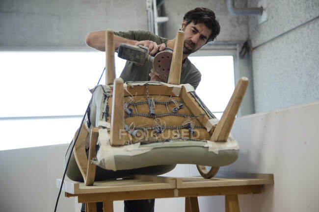 Junger Holzhandwerker arbeitet im Atelier — Stockfoto