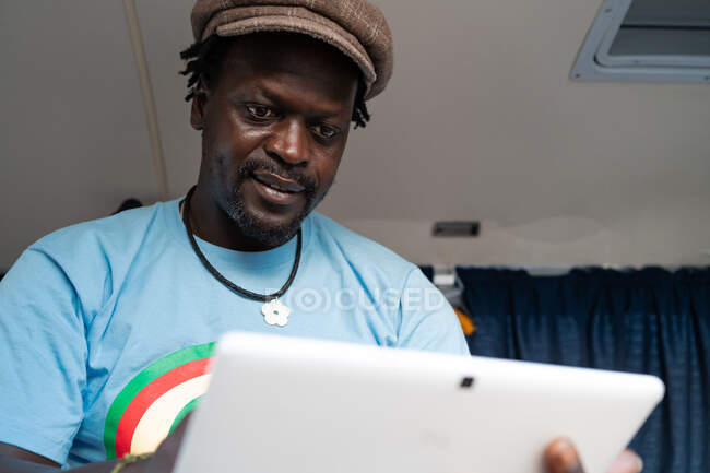 Afrikanischer schwarzer Junge arbeitet mit Tablet im Lieferwagen — Stockfoto