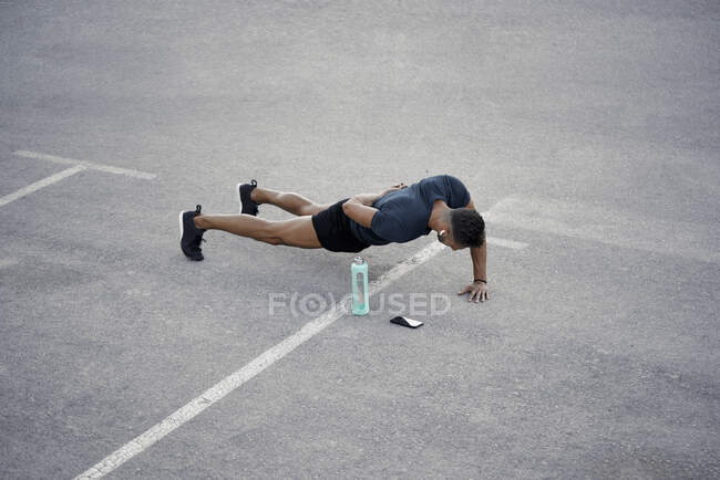 A young boy is doing push up exercises in the street. Calisthenic concept — Stock Photo