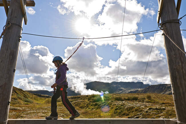 Menina está equilibrando sobre uma prancha em curso de acesso de corda alta na Islândia — Fotografia de Stock