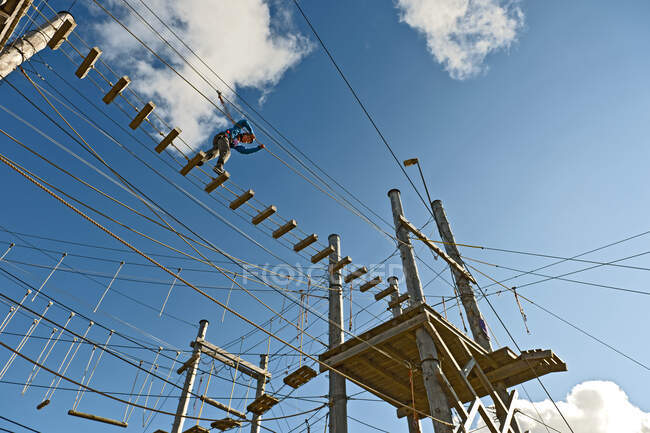Boy is balancing over a bridge at high rope access course in Iceland — Stock Photo