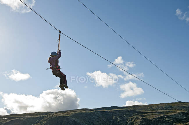 Girl going down on a zip line at high rope access course in Iceland — Stock Photo