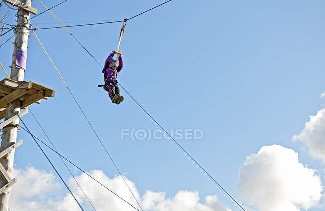 Girl going down on a zip line at high rope access course in Iceland — Stock Photo