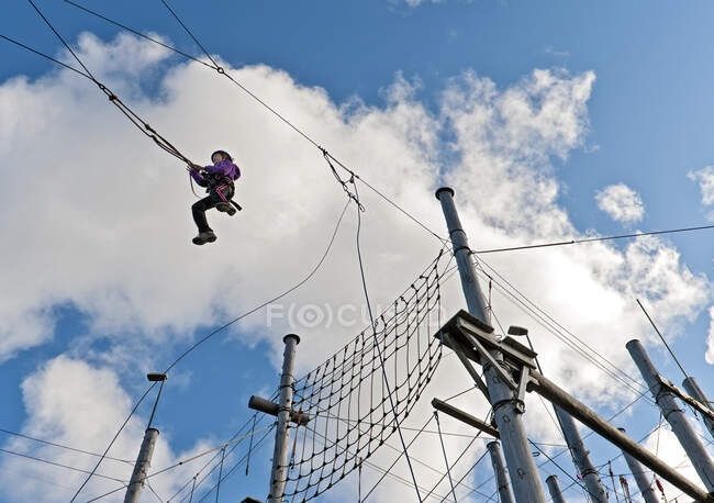 Menina em um balanço alto no curso de acesso de corda alta na Islândia — Fotografia de Stock