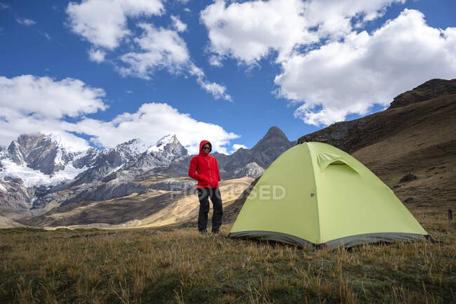 Uma mulher de pé em um acampamento de alta altitude ao lado de uma tenda em Huayhuash — Fotografia de Stock
