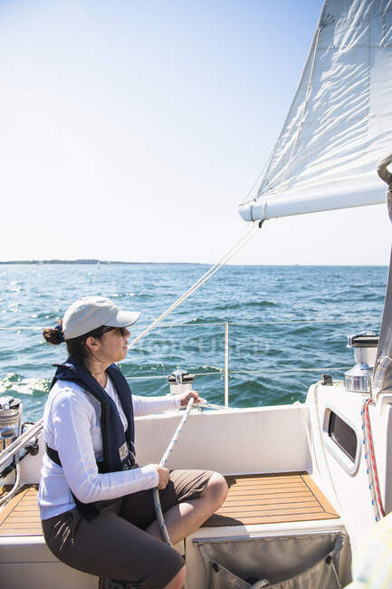 Young woman enjoying a family sail on sunny summer day — Stock Photo