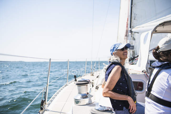 Donna di mezza età godendo di vela famiglia nella soleggiata giornata estiva — Foto stock