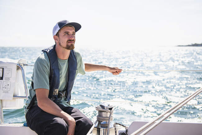 Людина в капелюсі на човні в морі — стокове фото