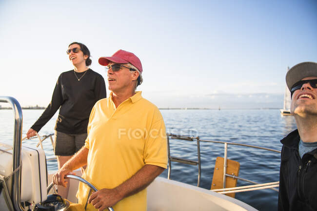 Family enjoying summer sail during golden hour — Stock Photo