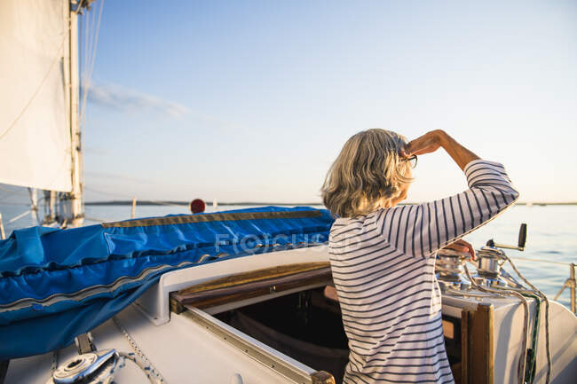 Donna di mezza età godendo vela estiva durante l'ora d'oro — Foto stock