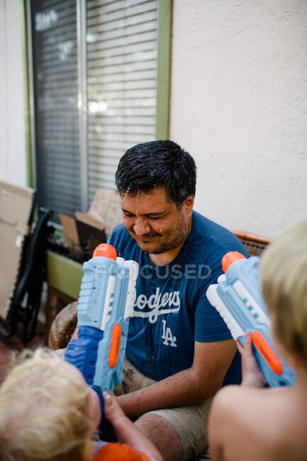 Brüder schießen mit Wasserpistolen auf Onkel — Stockfoto