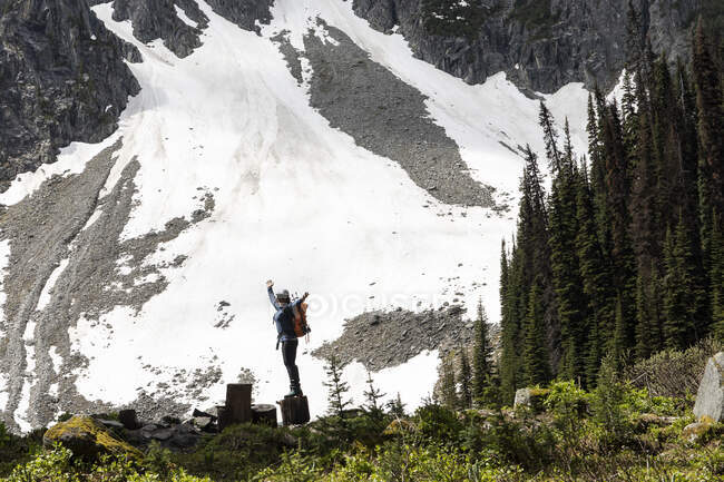 Anonimo escursionista in piedi vicino al pendio della montagna — Foto stock