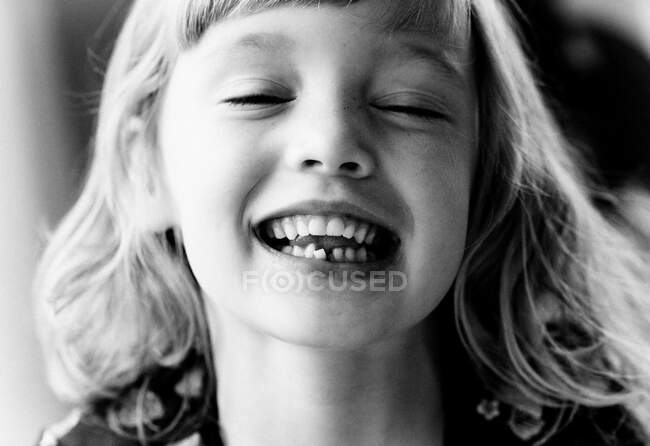 Портрет молодої дівчини, що показує її колисковий зуб, посміхаючись — стокове фото