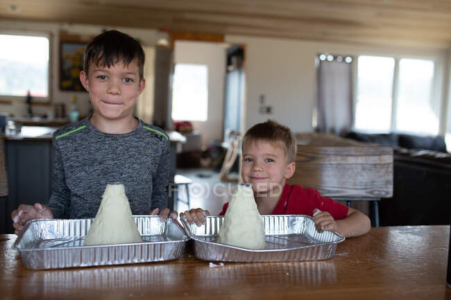 Brothers standing proud with their homemade volcanos — Stock Photo