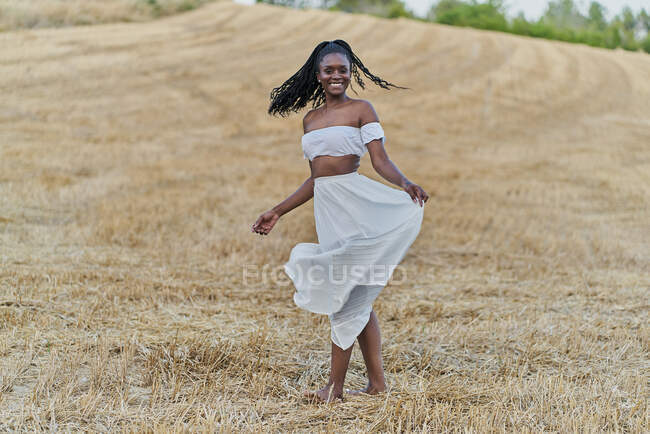 Фотосессия красивой черной женщины на пшеничном поле с белым платьем — стоковое фото
