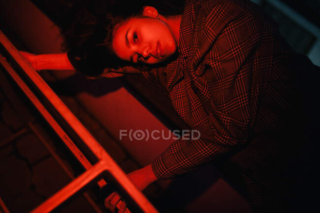 Mujer acostada iluminada por la luz roja - foto de stock