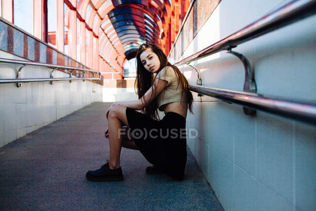 Jovem bela mulher sentada nas escadas e olhando para longe — Fotografia de Stock